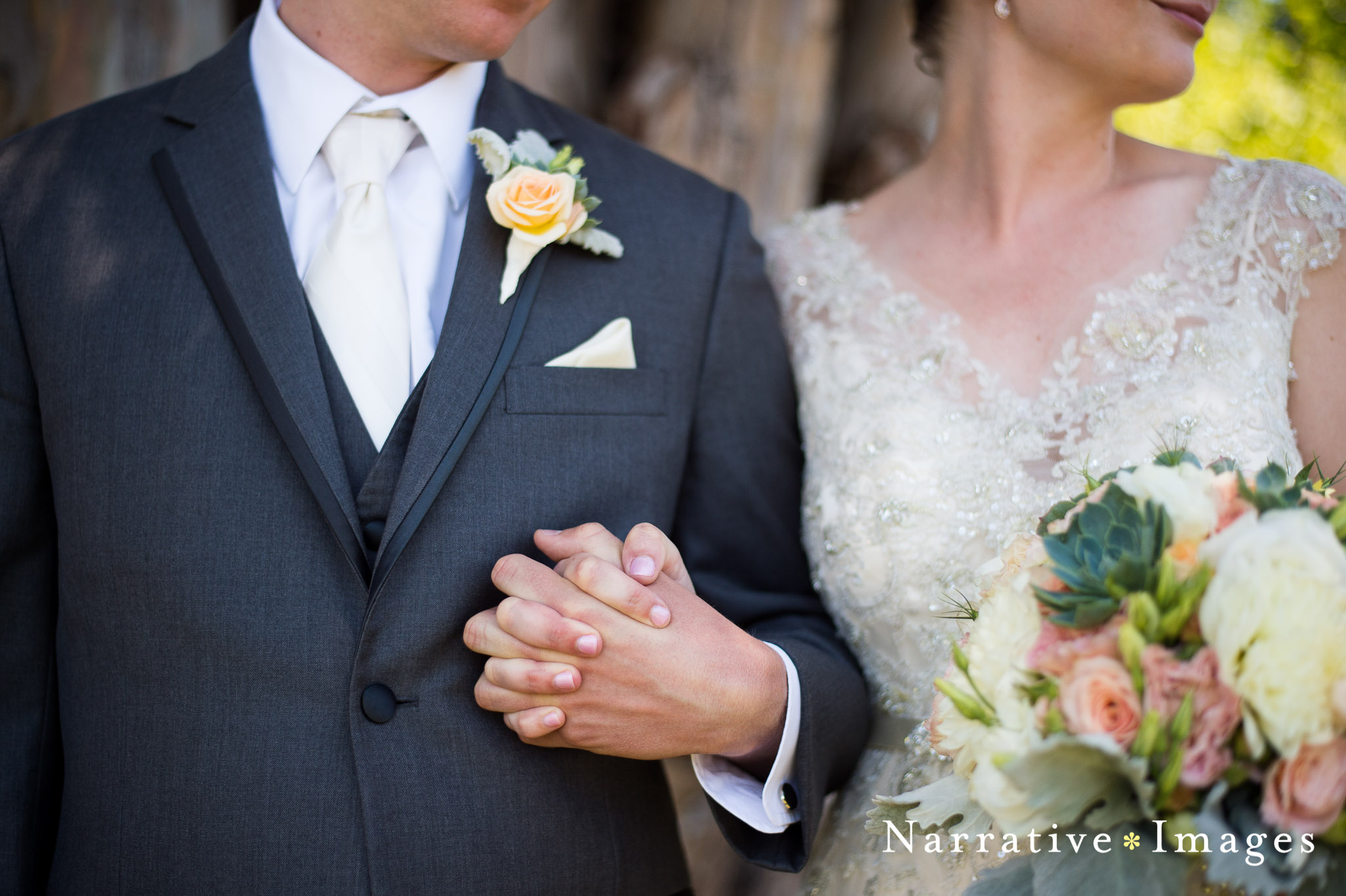 A detail shot of Groom and Bride's dress and tux and flowers