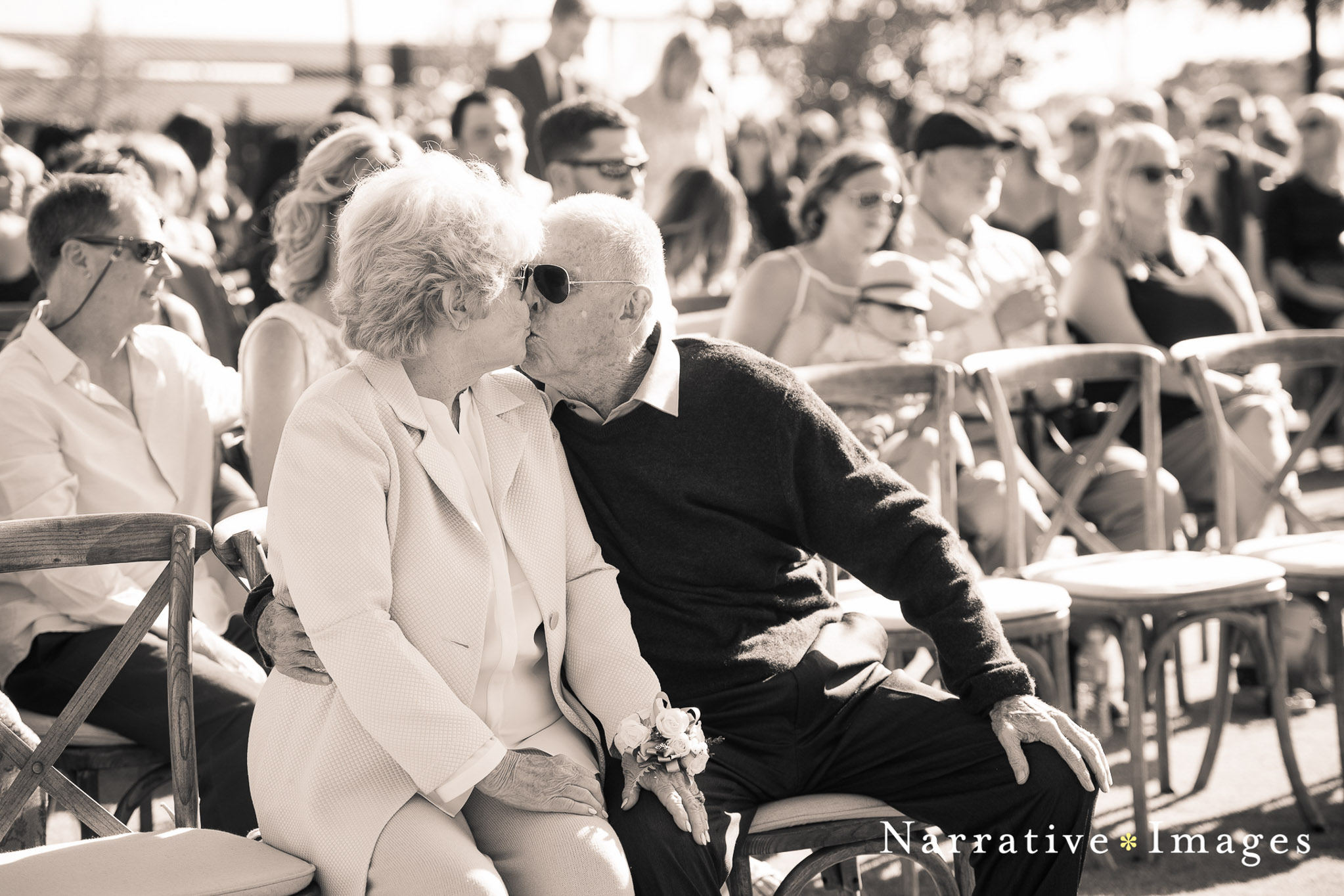 Grandparents kiss during wedding ceremony with guests not noticing