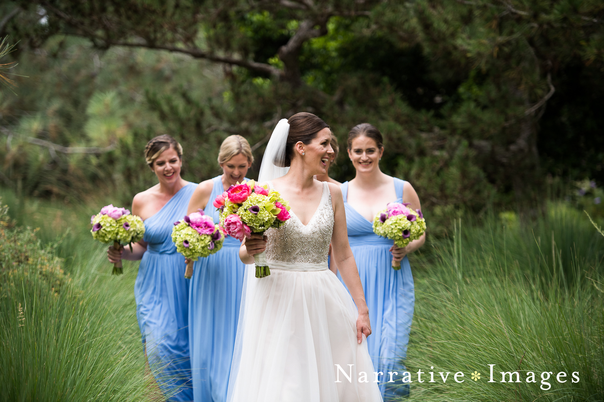 Bride and bridesmaids walk through gardens at Torrey Pines Lodge in La Jolla