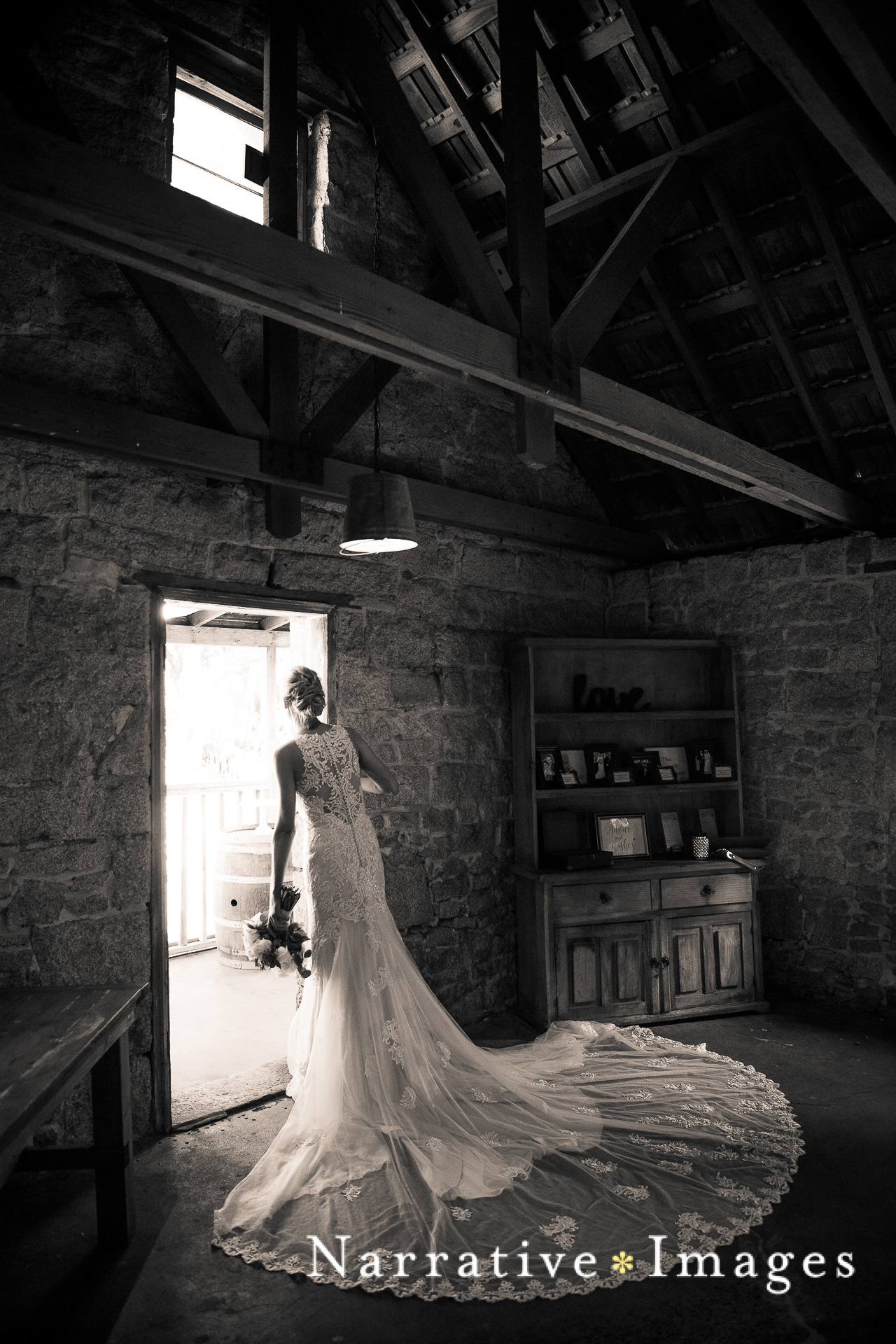 Bride looks out doorway at ceremony outside the Stone House at Temecula Creek Inn