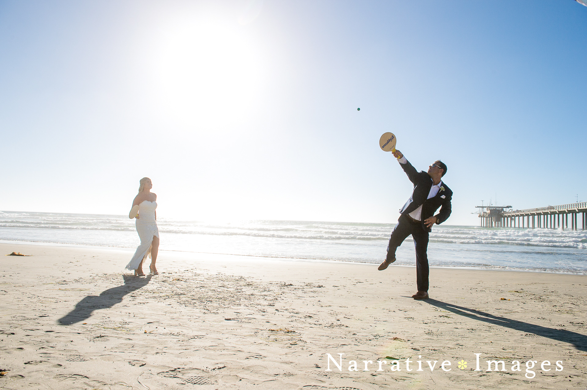 Bride and groom play Smashball on the beach at Scripps Seaside Forum in La Jolla