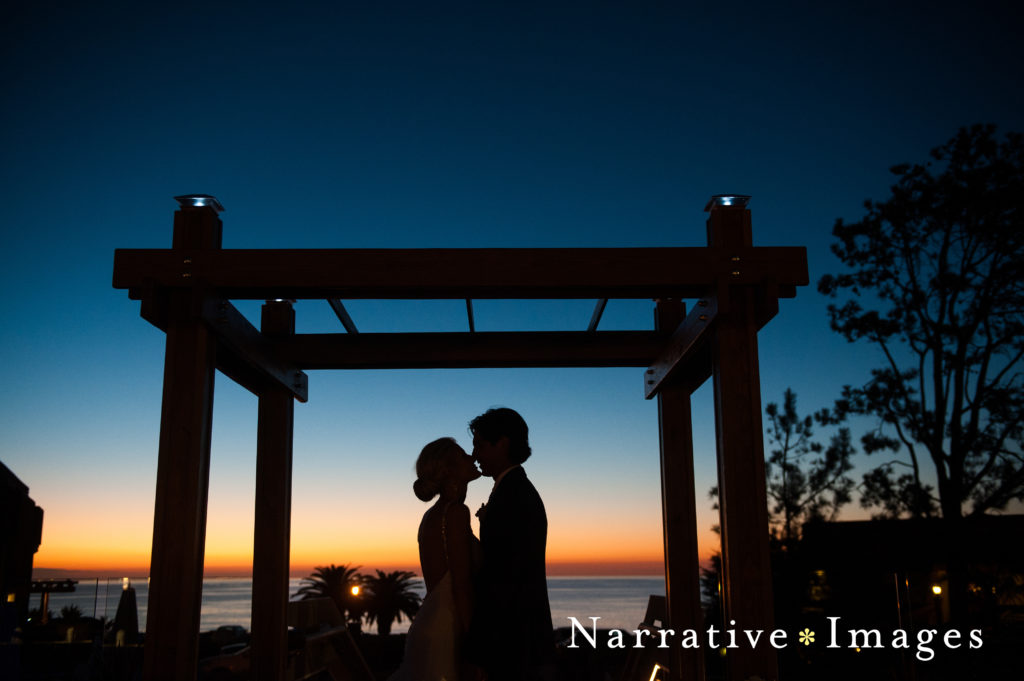 Silhouette of bride and groom kissing under wedding gazebo during after sunset at L'Auberge Del Mar