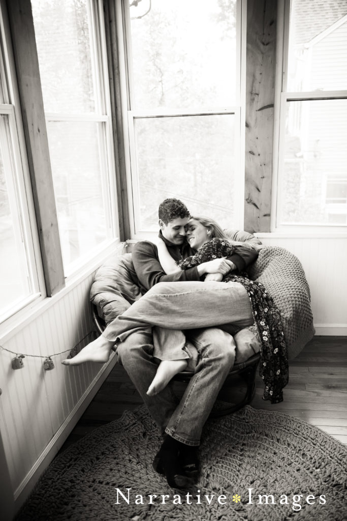 black and white image of couple cuddling on their papasan chair