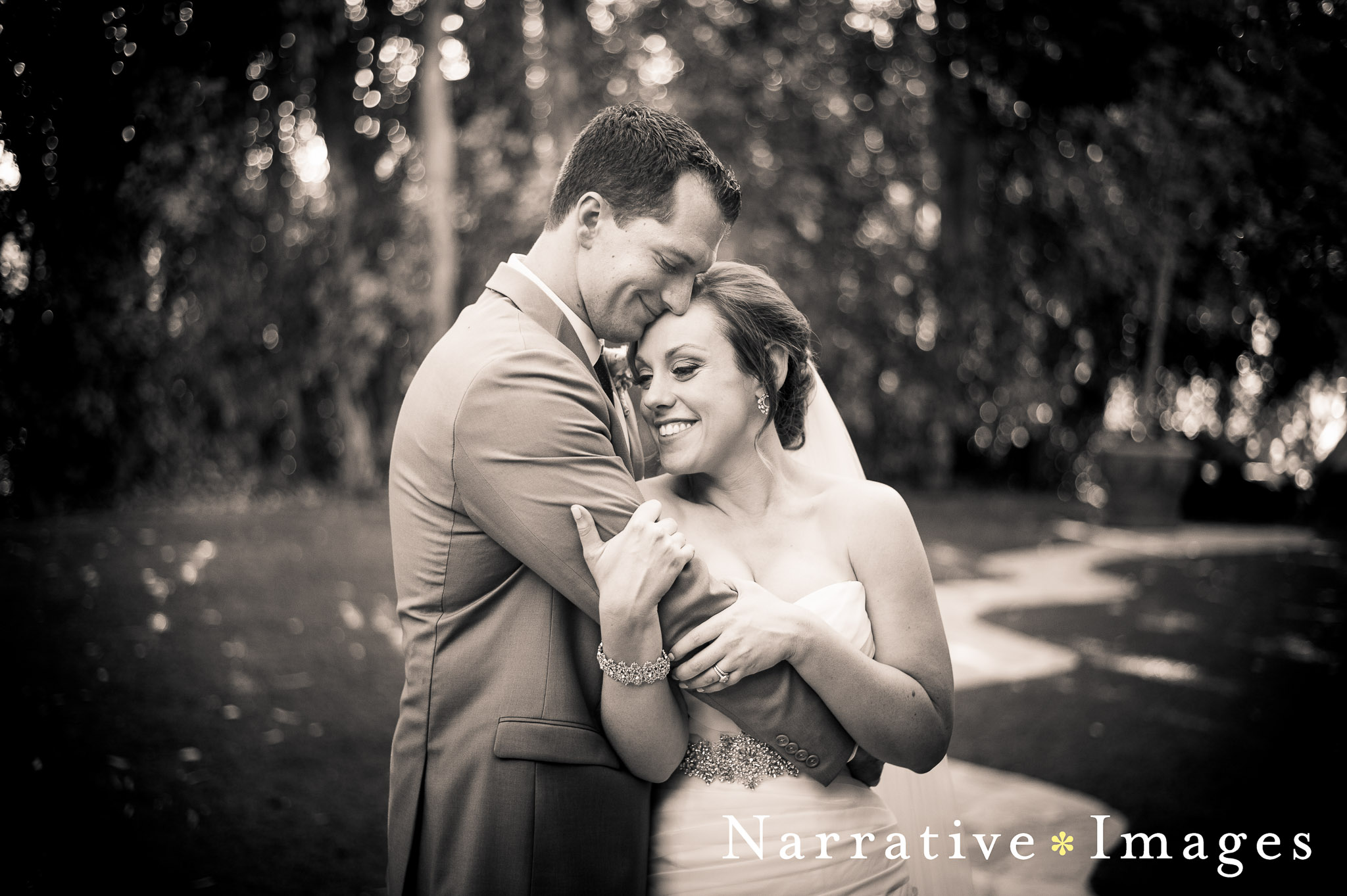 Bride and Groom hug outside the old school house at a vintage historic wedding venue twin oaks