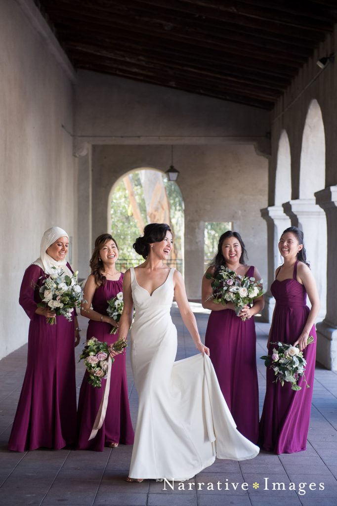 Balboa Park hallway photo of wedding party and bride laughing