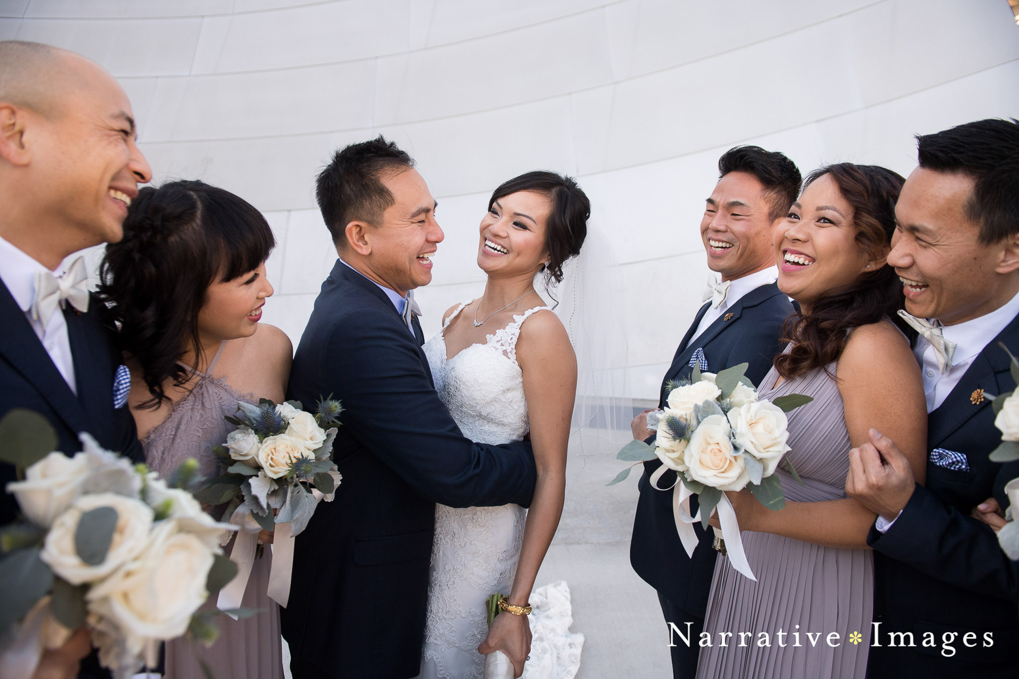 Bride and groom with wedding party laughing outside disney concert hall los angeles 