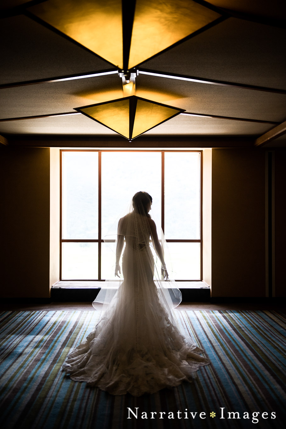 Bride in window with wedding dress and bright light Temecula winery wedding