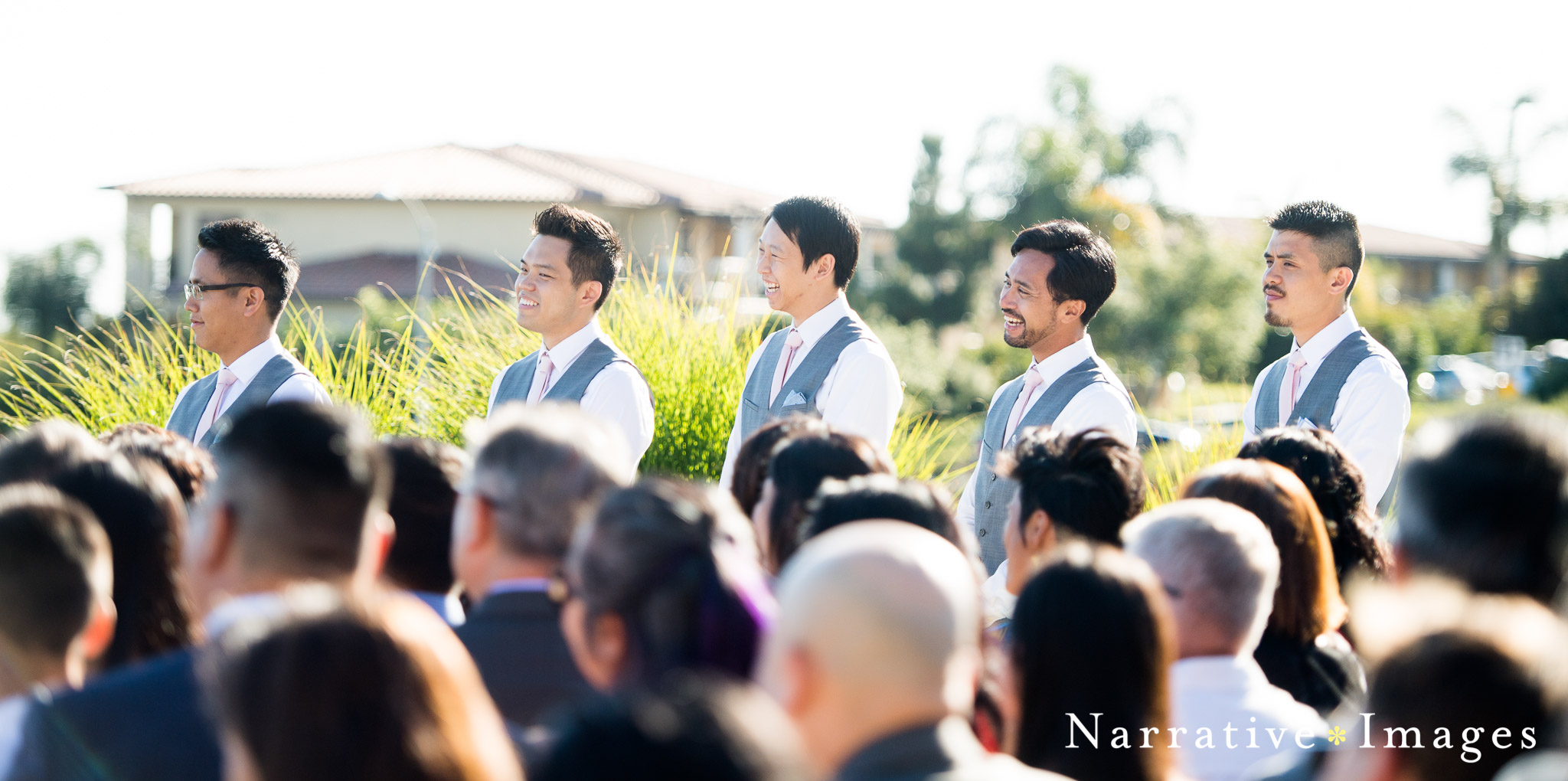 groomsmen watch couple get married at outdoor wedding venue
