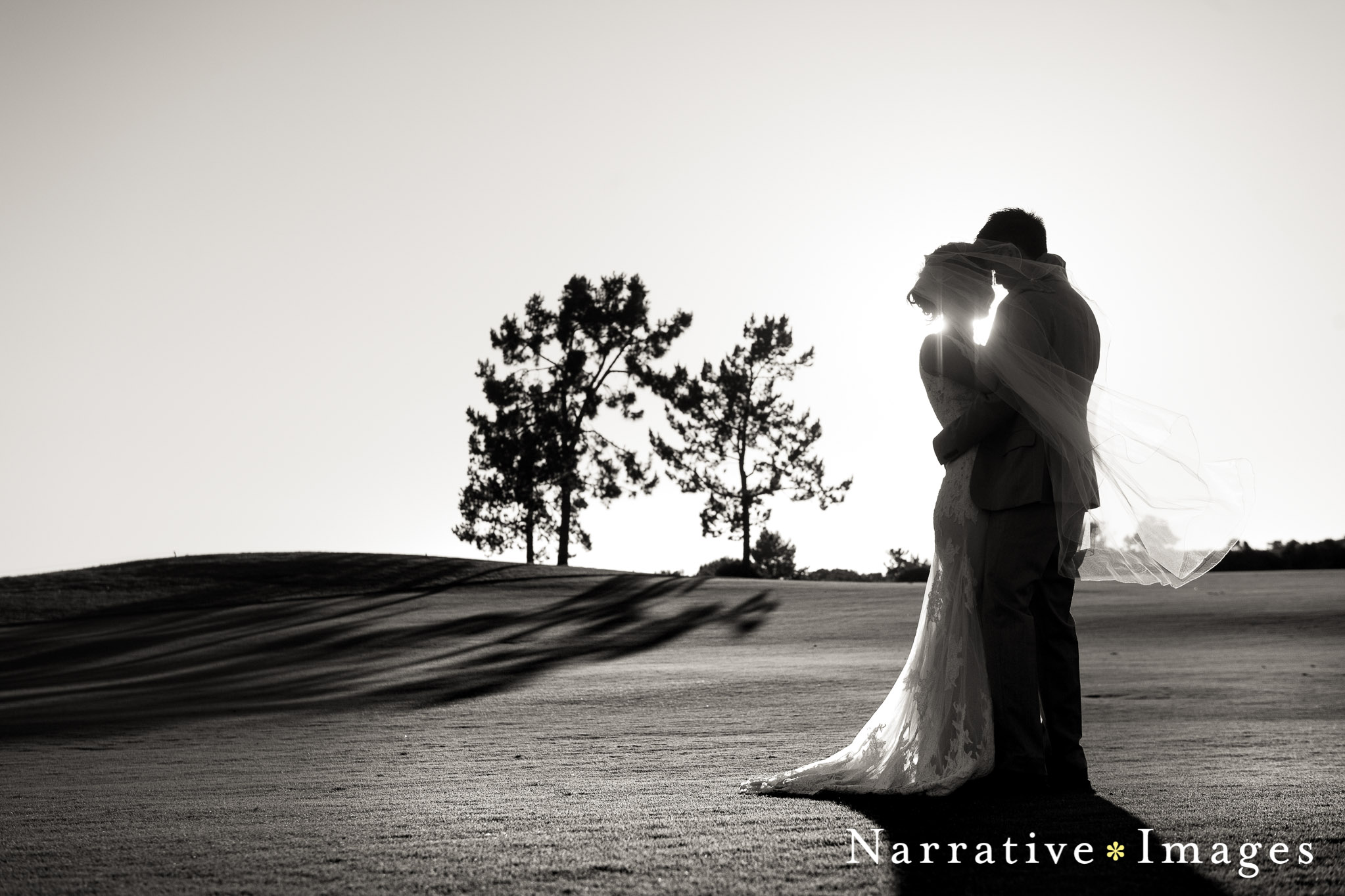 Bride and groom embrace during sunset on golf course in Carlsbad