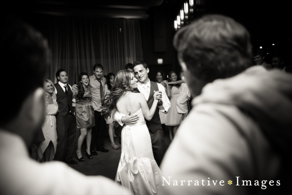 Bride and groom dance surrounded by their guests in black and white image at Scripps Seaside Forum in La Jolla, California.