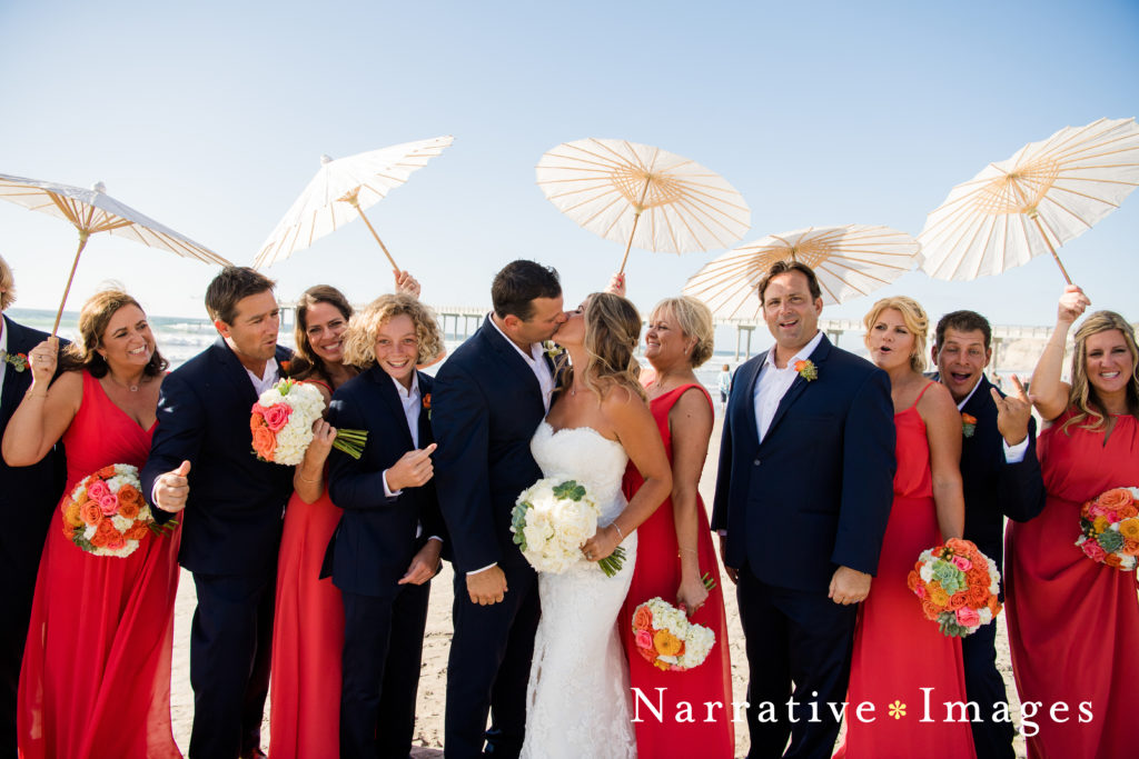Bride and groom kiss as wedding party cheers on Scripps Beach in La Jolla, California