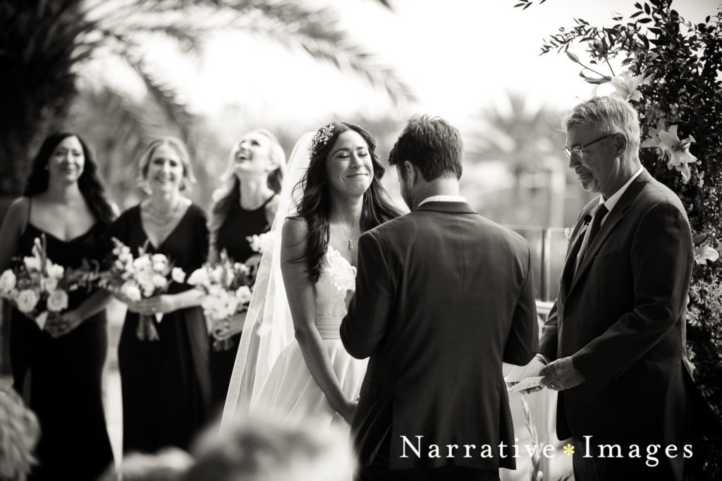 Bride smiles gently during wedding vows in black and white photo taken at The Lane wedding venue in San Diego